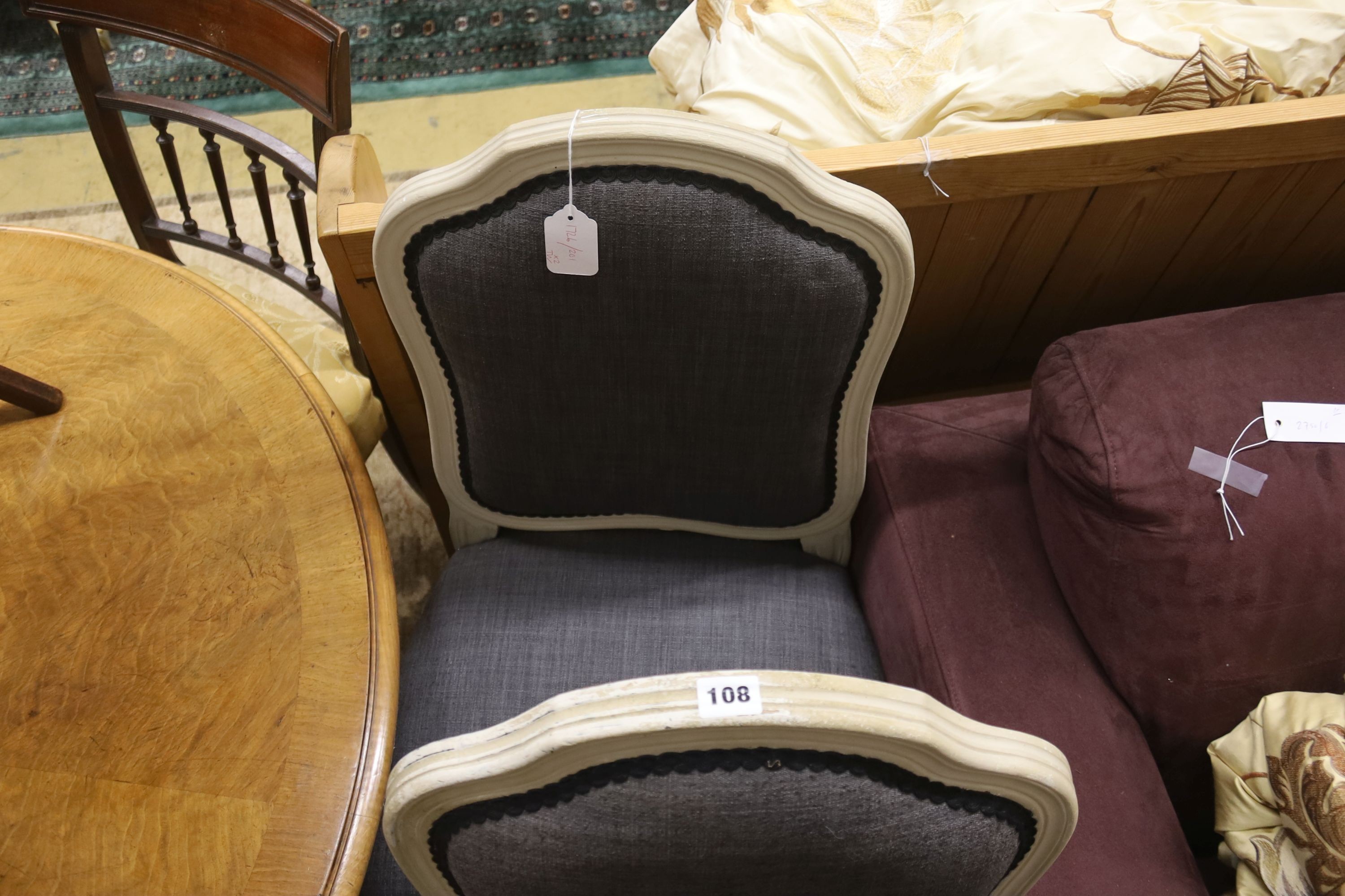 A pair of grey upholstered dining chairs